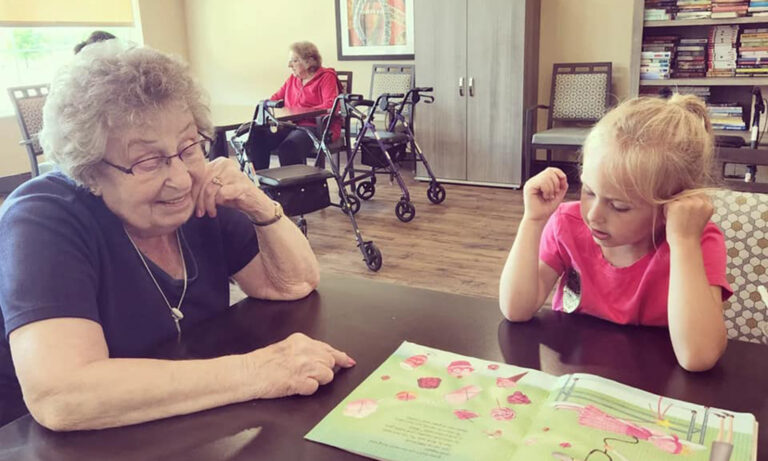 Senior resident sitting with female child