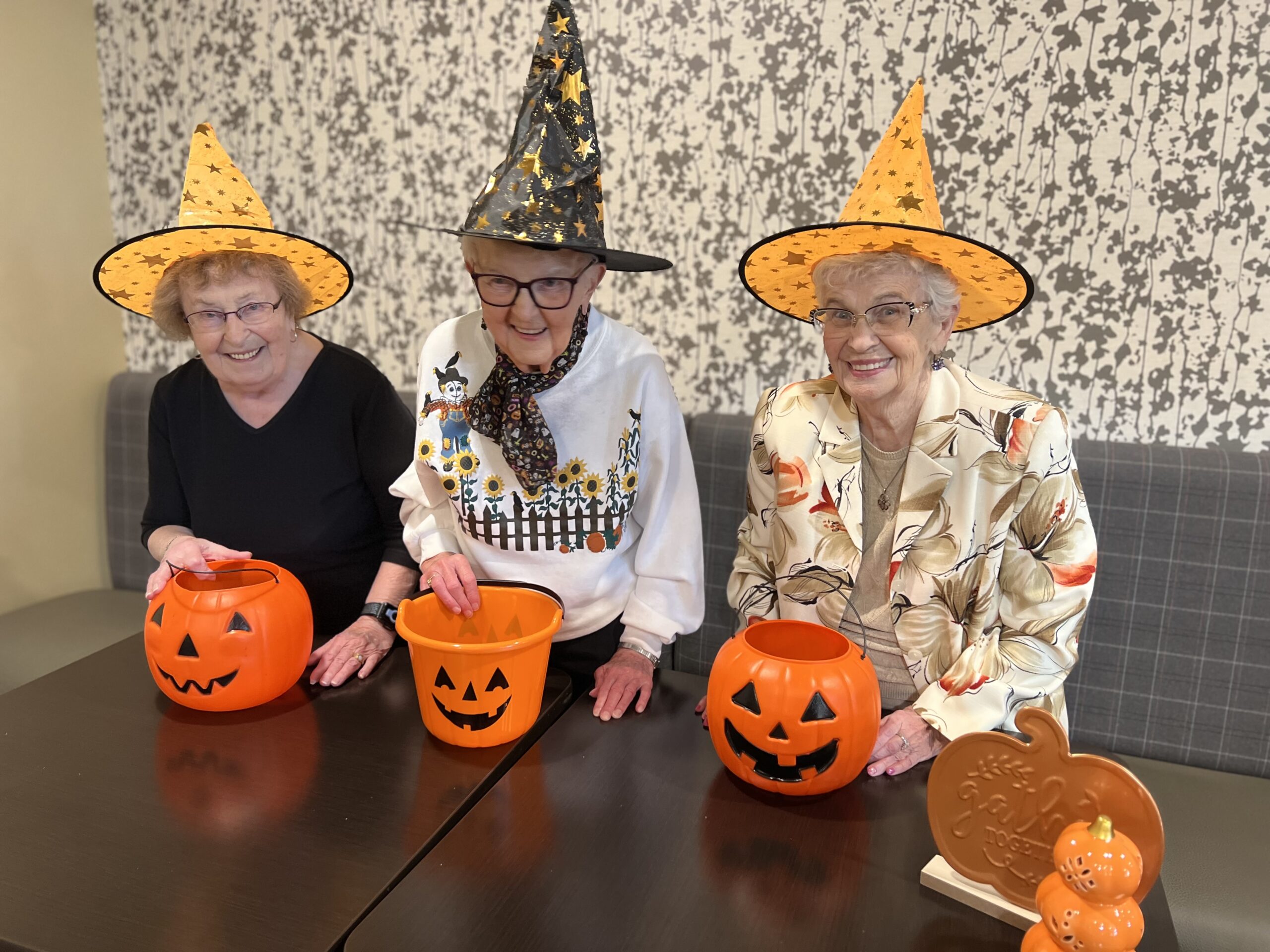 3 senior living ladies looking confident and happy with Halloween decor