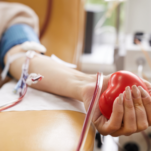 image of woman's arm holding a heart shaped squeeze ball and donating blood